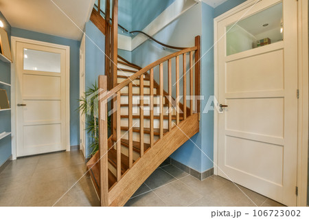 a staircase way in a house with blue walls and white trim on the stairs, there is an open door 106723002