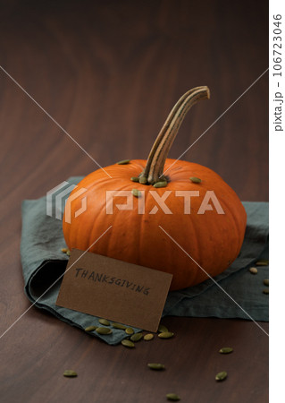 Orange pumpkin with seeds on wood table with thanksgiving paper card 106723046