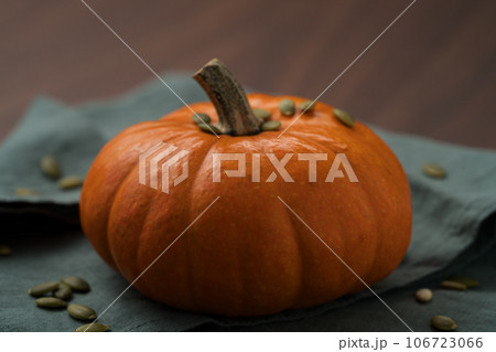 Orange pumpkin on linen napkin on wood table for seasonal background Orange pumpkin on linen napkin on wood table for seasonal background 106723066