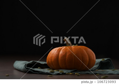 Orange pumpkin on linen napkin on wood table for seasonal background 106723093
