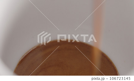 espresso pour into white cup closeup espresso pour into white cup closeup 106723145
