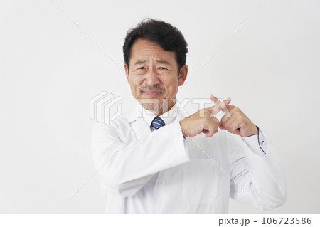 指でばつ印をする中年の医師　白背景 106723586