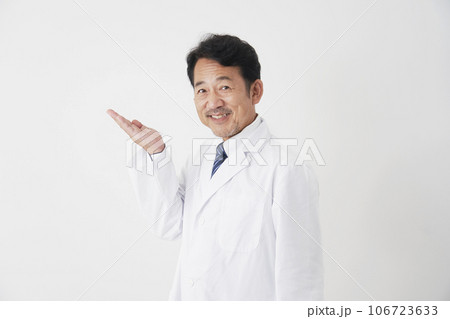 左側を手の平で指す中年の医師　白背景 106723633