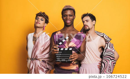 Three transgender male models posing with a film clapperboard 106724522