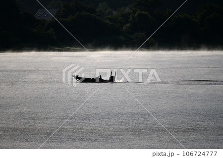 朝靄の中の湖 輝く水面 朝靄の中の湖 輝く水面 106724777