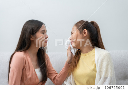 Two women talking about problems at home. Asian women embrace to calm their sad best friends from feeling down. Female friends supporting each other. Problems, friendship, and care concept Two women talking about problems at home. Asian women embrace to calm their sad best friends from feeling down. Female friends supporting each other. Problems, friendship, and care concept 106725001