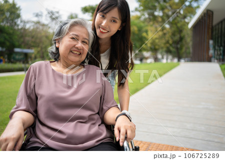 Asian careful caregiver or nurse taking care of the patient in a wheelchair. Concept of happy retirement with care from a caregiver and Savings and senior health insurance, a Happy family 106725289