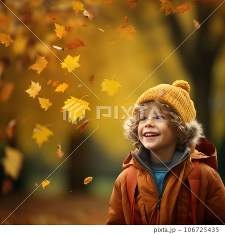 Happy 6-year-old boy looking at falling yellow leaves in an  autumn 106725435