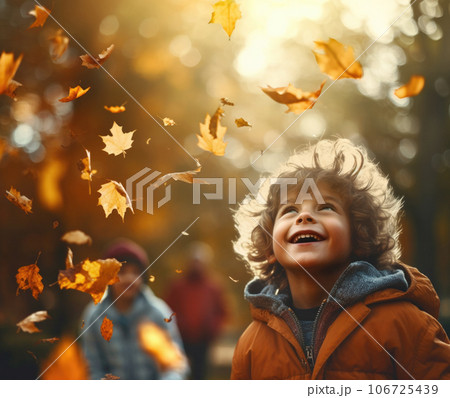 5-year-old boy in autumn park looking in pure excitement at a shower of falling autumn leaves 106725439