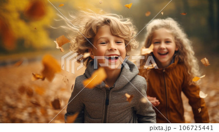 6-year-old laughing children running through a field of fallen leaves 106725441