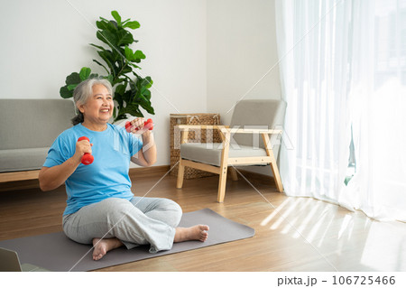 Asian senior woman lifting dumbbell for exercise and workout at home. Active mature woman doing stretching exercise in living room. Exercise Active and healthy for older, elder, and senior concept. Asian senior woman lifting dumbbell for exercise and workout at home. Active mature woman doing stretching exercise in living room. Exercise Active and healthy for older, elder, and senior concept. 106725466