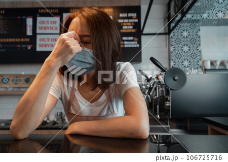 Asian woman coffee shop business owner Stressed and disappointed from The effects of the coronavirus pandemic resulting in business losses 106725716