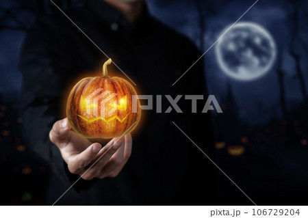 Supports hand the head of a Halloween pumpkin. Supports hand the head of a Halloween pumpkin. 106729204