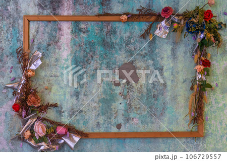 Empty wooden frame with flowers and dry leaves on blue Empty wooden frame with flowers and dry leaves on blue 106729557