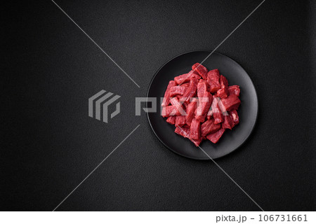 Raw organic meat beef or lamb cut into slices with salt, spices and herbs 106731661