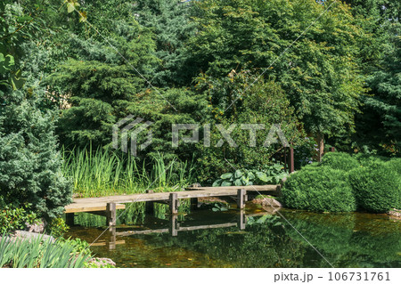 zigzag bridge over a pond in japanese garden 106731761