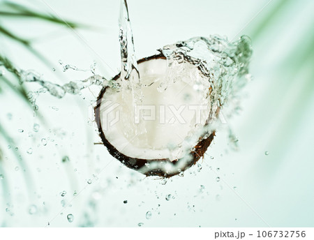 Cracked Coconut with water splash flying in the air, isolated on white. 106732756