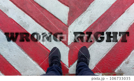 A man standing between wrong and right word.He is wearing black Shout and standing on Metal floor. go,grow. Photo choose and sign concept idea. 106733035
