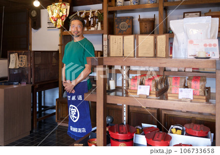 笑顔で視線を向ける味噌醤油販売店の主人 106733658