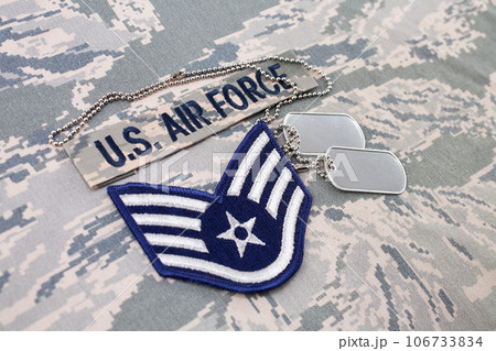 August 31, 2020. US AIR FORCE branch tape and Staff Sergeant rank patch and dog tags on digital tiger-stripe pattern Airman Battle Uniform August 31, 2020. US AIR FORCE branch tape and Staff Sergeant rank patch and dog tags on digital tiger-stripe pattern Airman Battle Uniform 106733834