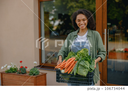 Smiling woman farmer with just harvested vegetables basket ready to sale. Agricultural concept 106734044