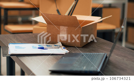 Office space in storage room filled with shipping boxes, warehouse used for products distribution and quality control management. Small business place with merchandise and goods. 106734321