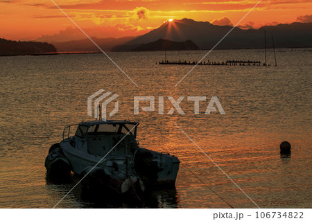 瀬戸内の漁港に昇る朝陽 106734822