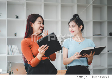Business woman talking to her colleague during a meeting in a boardroom, Business team working on digital tablet. 106735051
