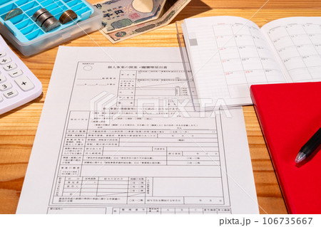 机に展開された開業届出書とスケジュール帳とお金と文房具たち 106735667