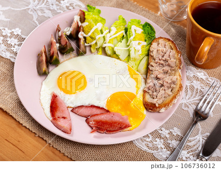 Serving plate with scrambled eggs, ham, tomatoes, brussels sprouts and tuna sandwich Serving plate with scrambled eggs, ham, tomatoes, brussels sprouts and tuna sandwich 106736012