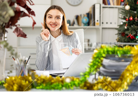 Portrait of happy female manager with money in an envelope - christmas present Portrait of happy female manager with money in an envelope - christmas present 106736013