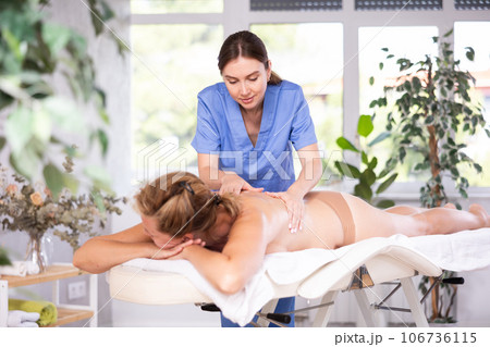 Portrait of woman relaxing on massage table at spa center Portrait of woman relaxing on massage table at spa center 106736115