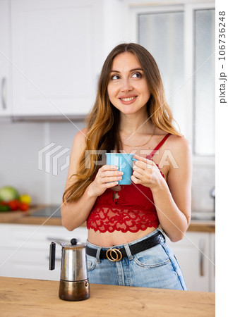 Woman drinking coffee at kitchen in morning 106736248