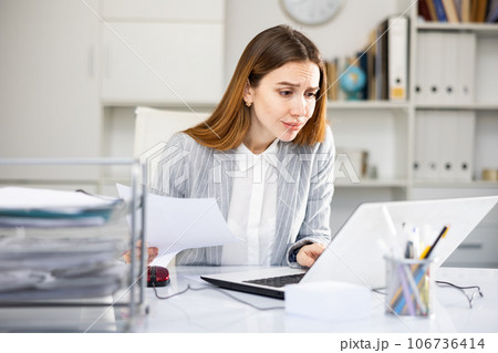 Tired businesswoman working with documents in office 106736414