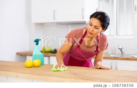Woman cleaning table with rag at home Woman cleaning table with rag at home 106736556