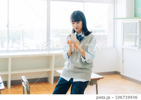 スマホを持つパンツスタイルの女子高生 スマホを持つパンツスタイルの女子高生 106739936