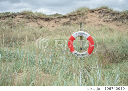 A lifebuoy sign in the dunes of laholm standing in the gras of melbystrand Sweden 106740010