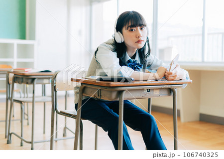 音楽を聴くパンツスタイルの女子高生 音楽を聴くパンツスタイルの女子高生 106740325