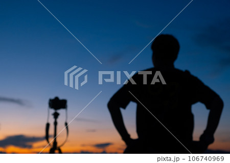 Blurred image of male photographer take a beautiful photograph of the sky when the sunrise or sunset. Blurred image of male photographer take a beautiful photograph of the sky when the sunrise or sunset. 106740969