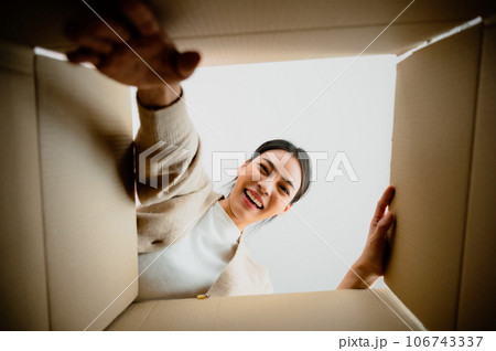 Surprised young asian woman unpacking 106743337