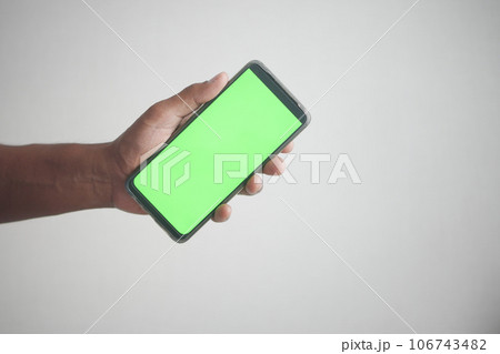 Close up of young man hand using smart phone with green screen  106743482