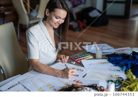Woman drawing sketches of swimwear and underwear in watercolor.  106744353