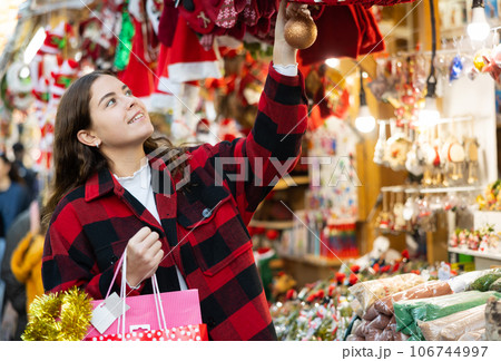 Happy young girl walking through street Christmas fair 106744997