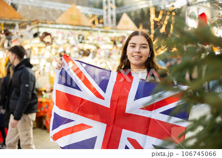 Young woman waving the United Kingdom flag at New Year street fair Young woman waving the United Kingdom flag at New Year street fair 106745066