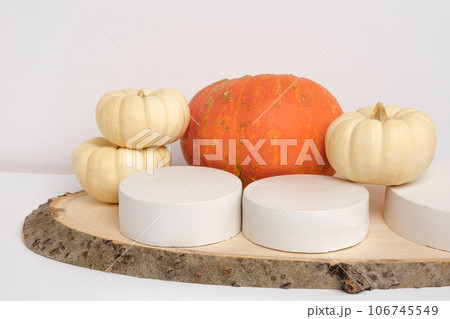 Podium for Presentation on Wooden Stand with Autumn Pumpkin Decoration on White Wall Background. Modern Geometrical Form. Cylinder Sphere. Scene to Show Product. Showcase, Display Case. Trendy. 3D Podium for Presentation on Wooden Stand with Autumn Pumpkin Decoration on White Wall Background. Modern Geometrical Form. Cylinder Sphere. Scene to Show Product. Showcase, Display Case. Trendy. 3D 106745549