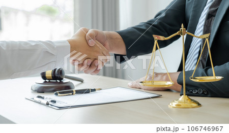 Handshake after Lawyer providing legal consult business dispute service to the man at the office with justice scale and gavel hammer Handshake after Lawyer providing legal consult business dispute service to the man at the office with justice scale and gavel hammer 106746967