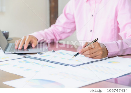Businessmen bookkeeper hand holding pen and use laptop doing account for paying tax in working office 106747454