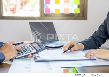 hand holding pen, businesswomen and businessmen team meeting to plan strategies to increase business income. 106747502
