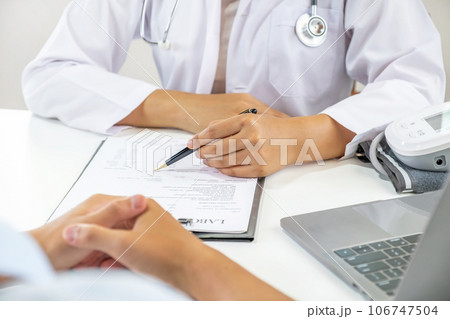 Doctor hand holding pen and explained examination results to the patient man, healthcare and medical checkup concept 106747504