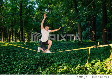 Man in sportswear balancing on the rope 106748793